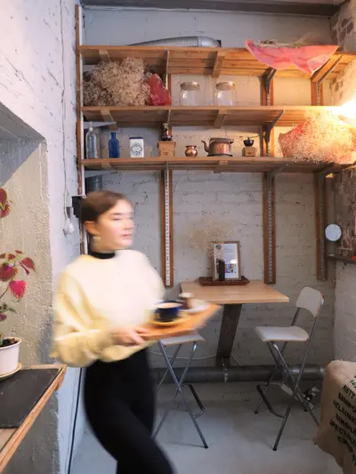 Kahvihuone, jossa on henkilö tarjottimen kanssa.