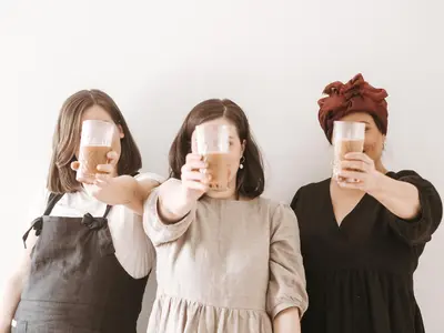 Kolme henkilö seisoo lasit kädessä.